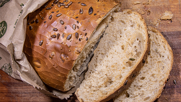 brot laib mit sonnenblumenkernen davon zwei scheiben abgeschnitten