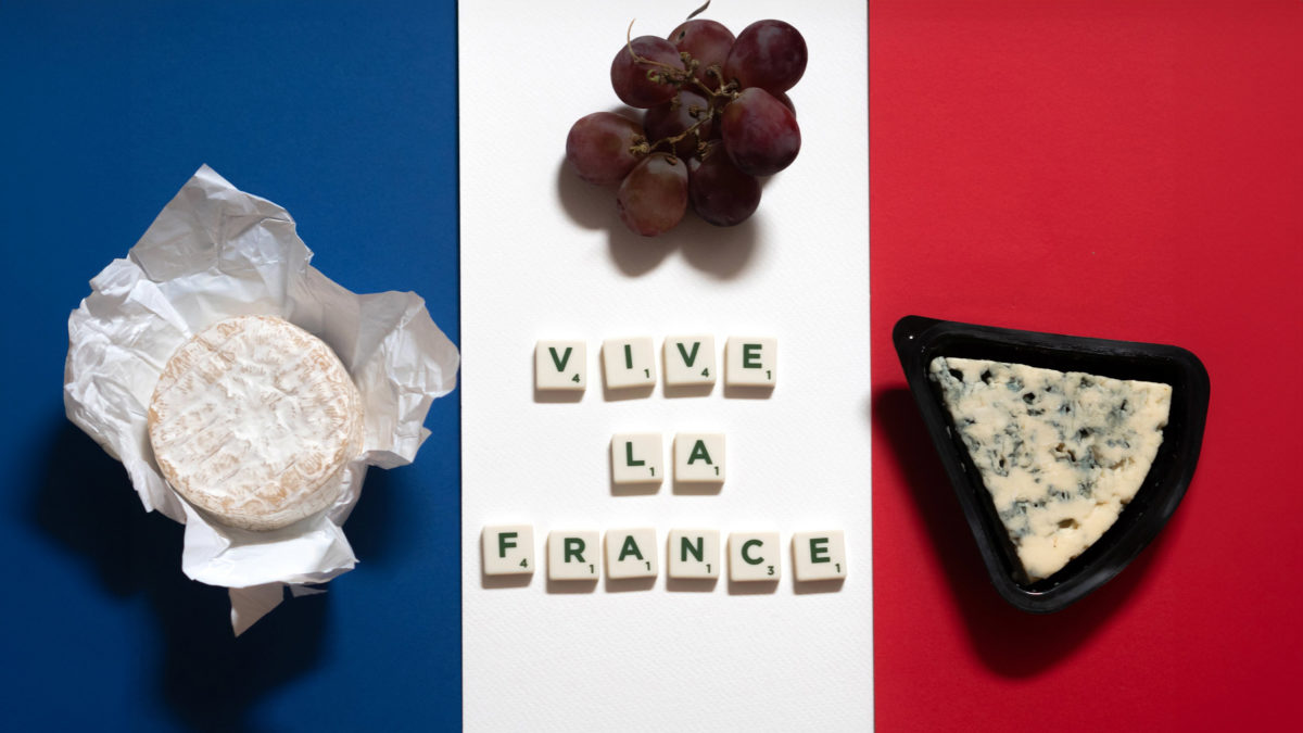 vive la france mit käse und weintrauben auf einer französischen flagge