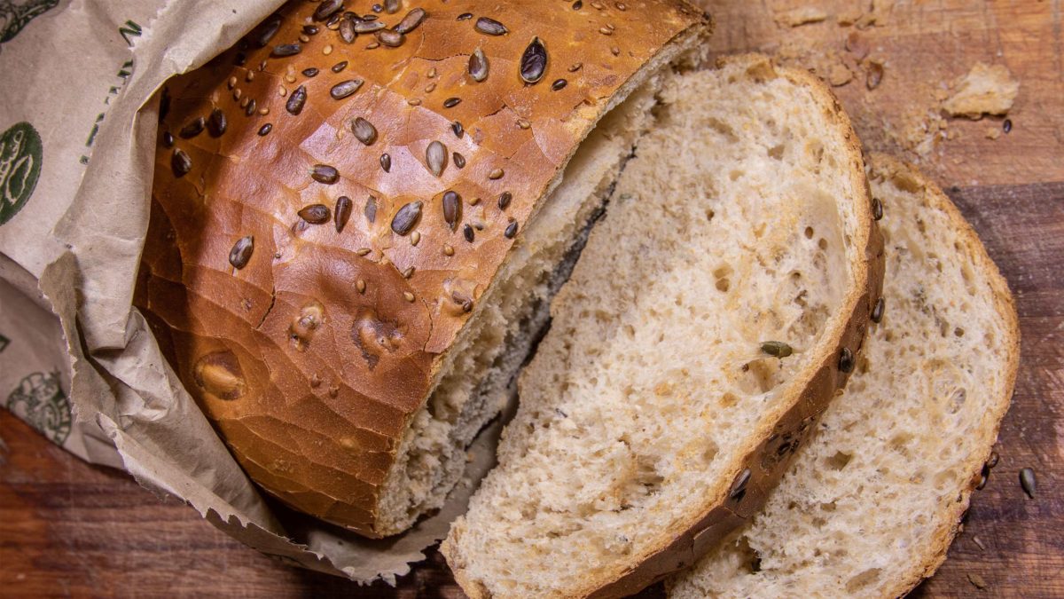 brot mit sonnenblumenkernen und zwei abgeschnittenen scheiben