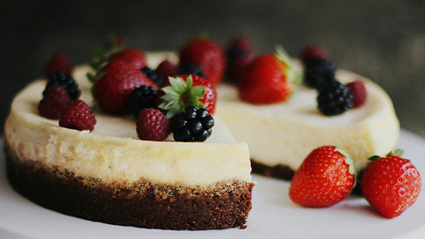 angeschnittener käsekuchen mit beeren topping