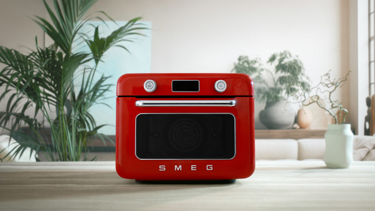 smeg mini backofen in rot vor pflanzen